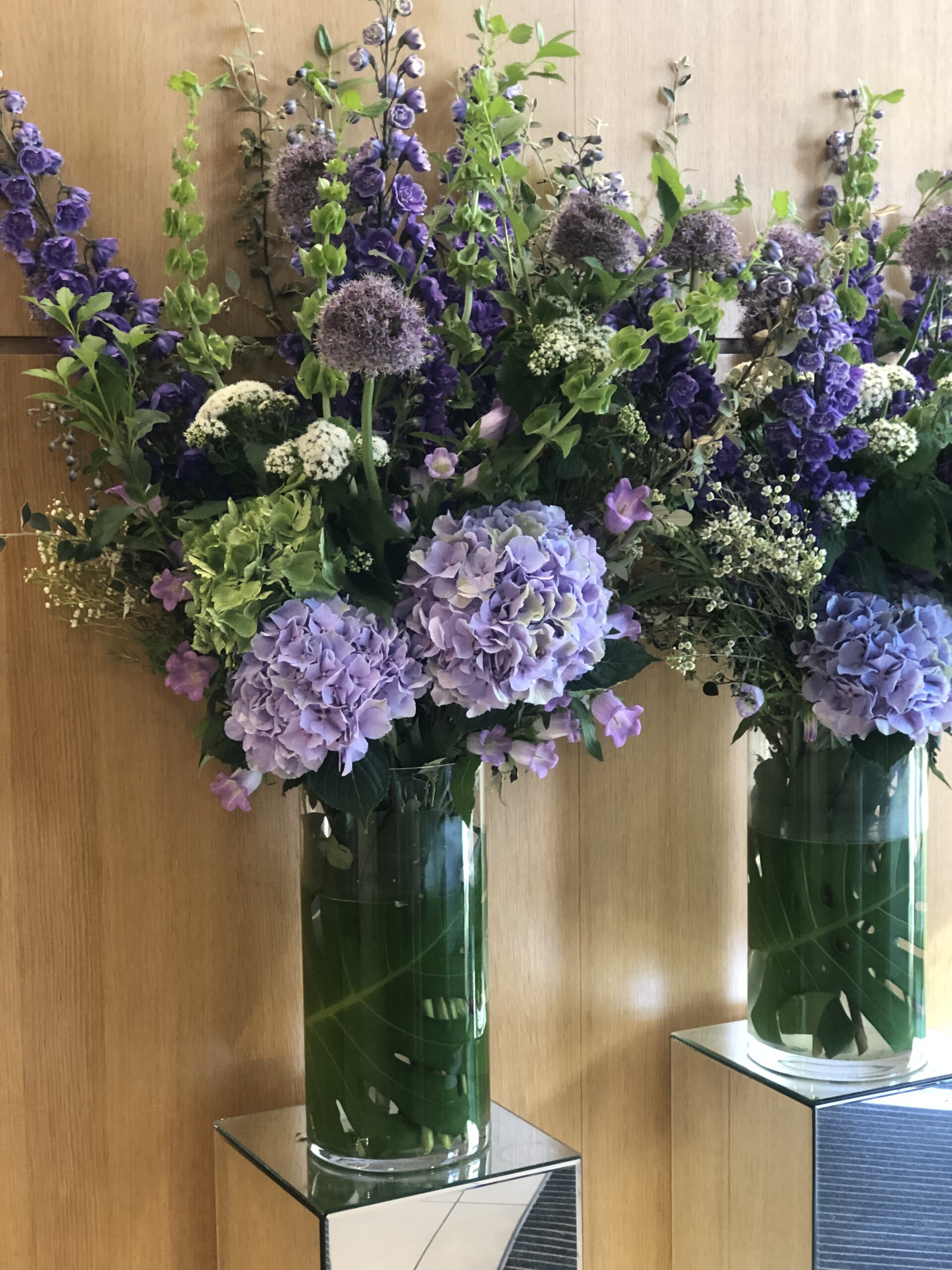Tall vase of purple and green flowers