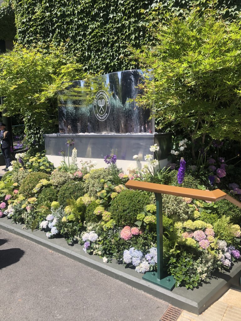 water sign at Wimbledon surrounded by flowersd